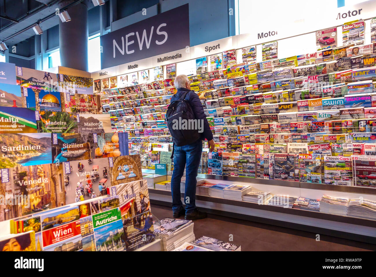 Passenger before departure buying magazines and newspapers, Vienna Airport Stock Photo