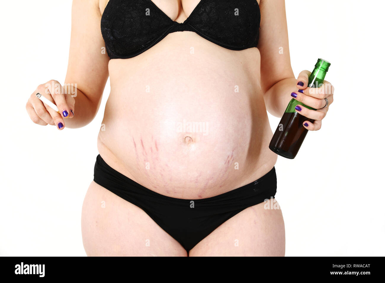 A pregnant woman shows her baby belly. In her hands she holds a cigarette  and a bottle of beer. An example of bad behaviour during pregnancy Stock  Photo - Alamy