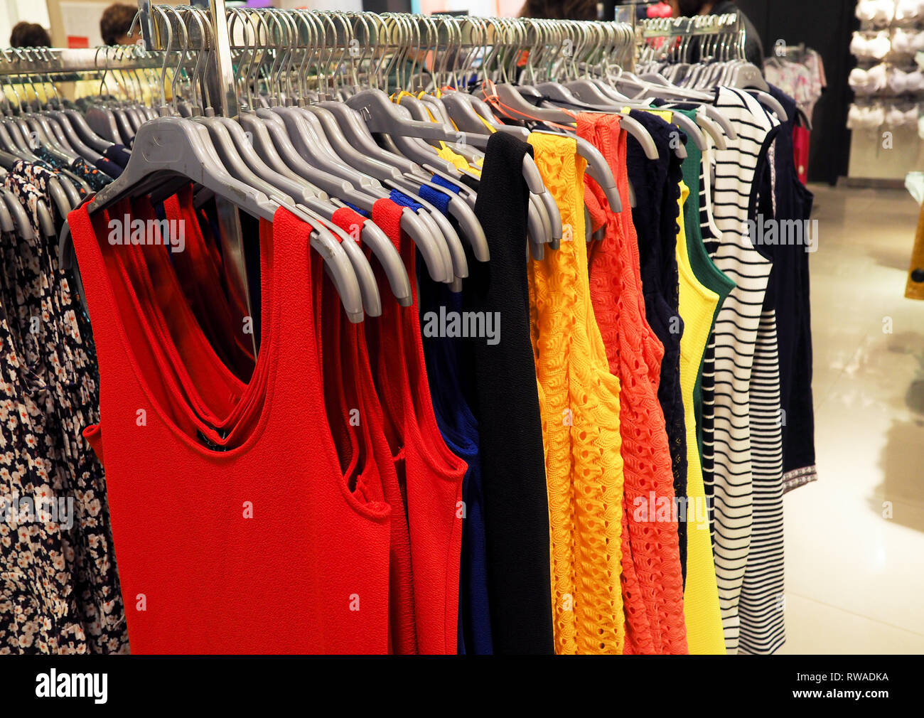colorful clothes hanging on the hanger in the showroom. Stock Photo