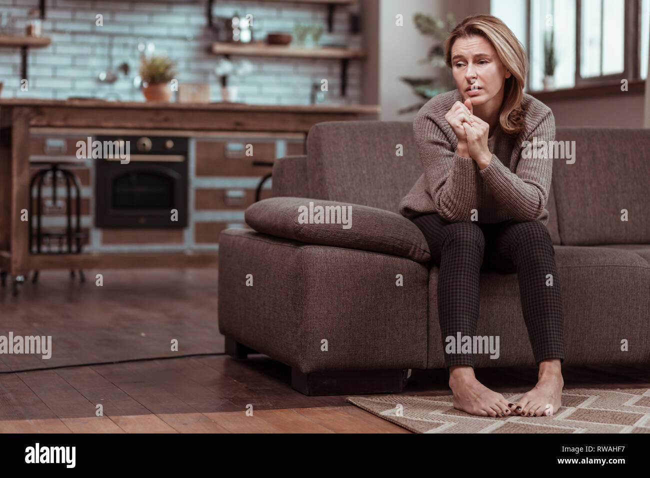 Mature woman thinking at home hi-res stock photography and images - Alamy
