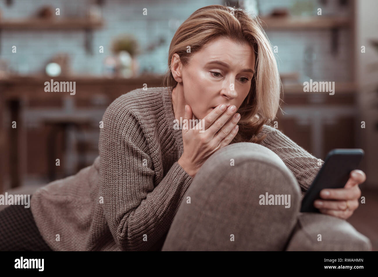 Woman feeling emotional after seeing message from husband Stock Photo