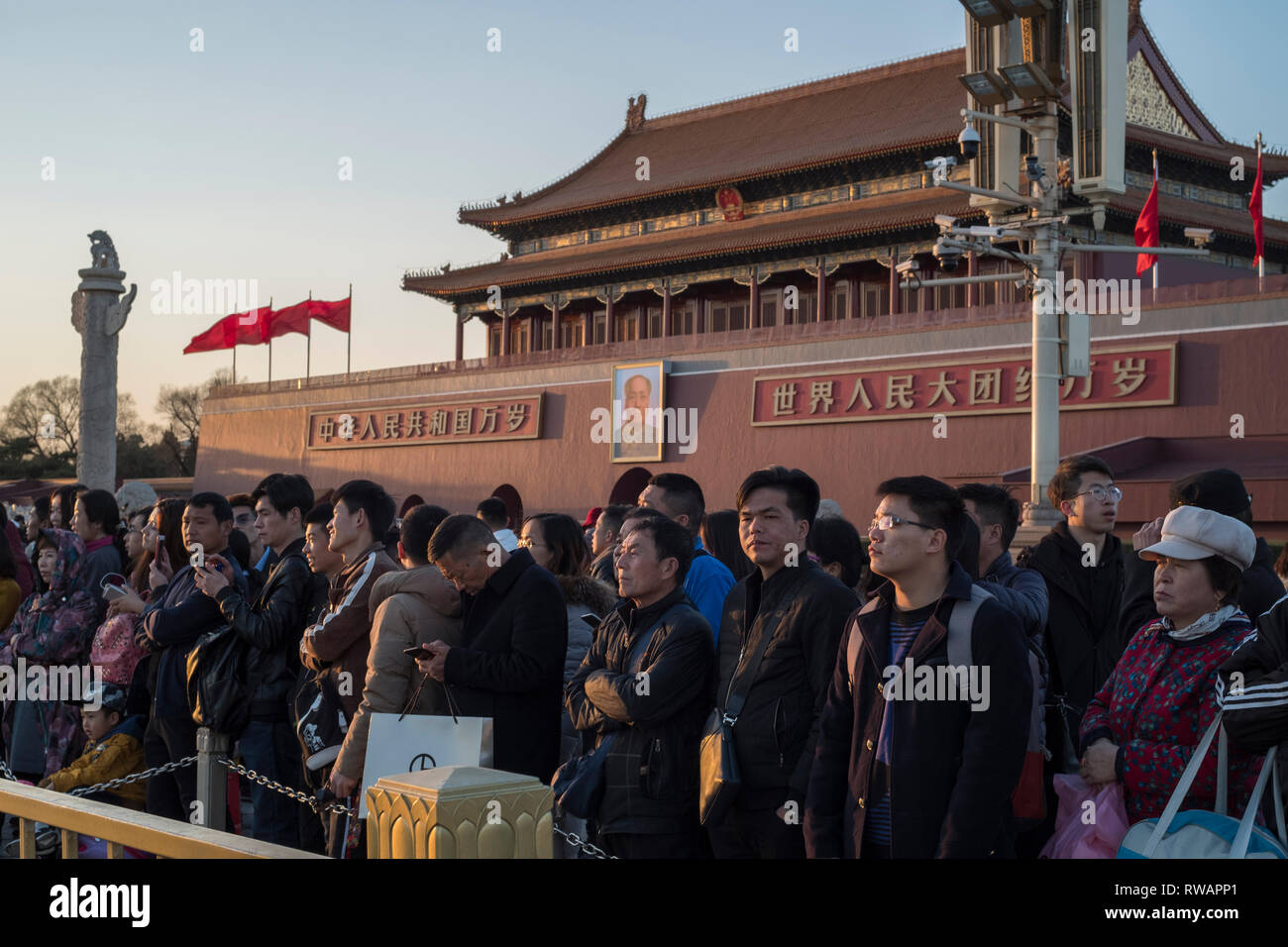 People gather to watch a flag-lowering ceremony in front of Tiananmen Gate in Beijing, China. 05-Mar-2019 Stock Photo