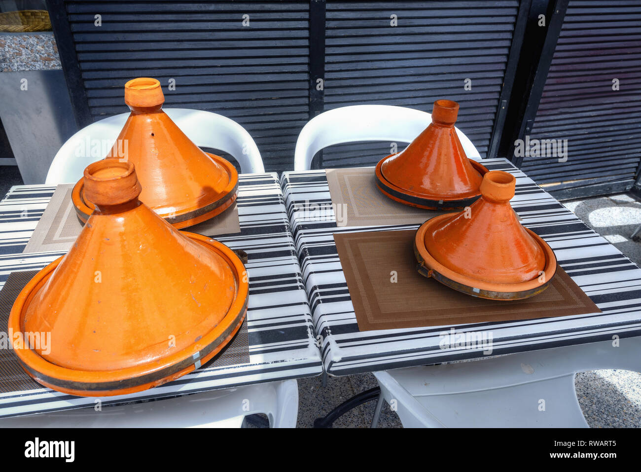 Moroccan food in traditional ceramic tagines in street cafe in Marrakesh. Morocco, North Africa Stock Photo