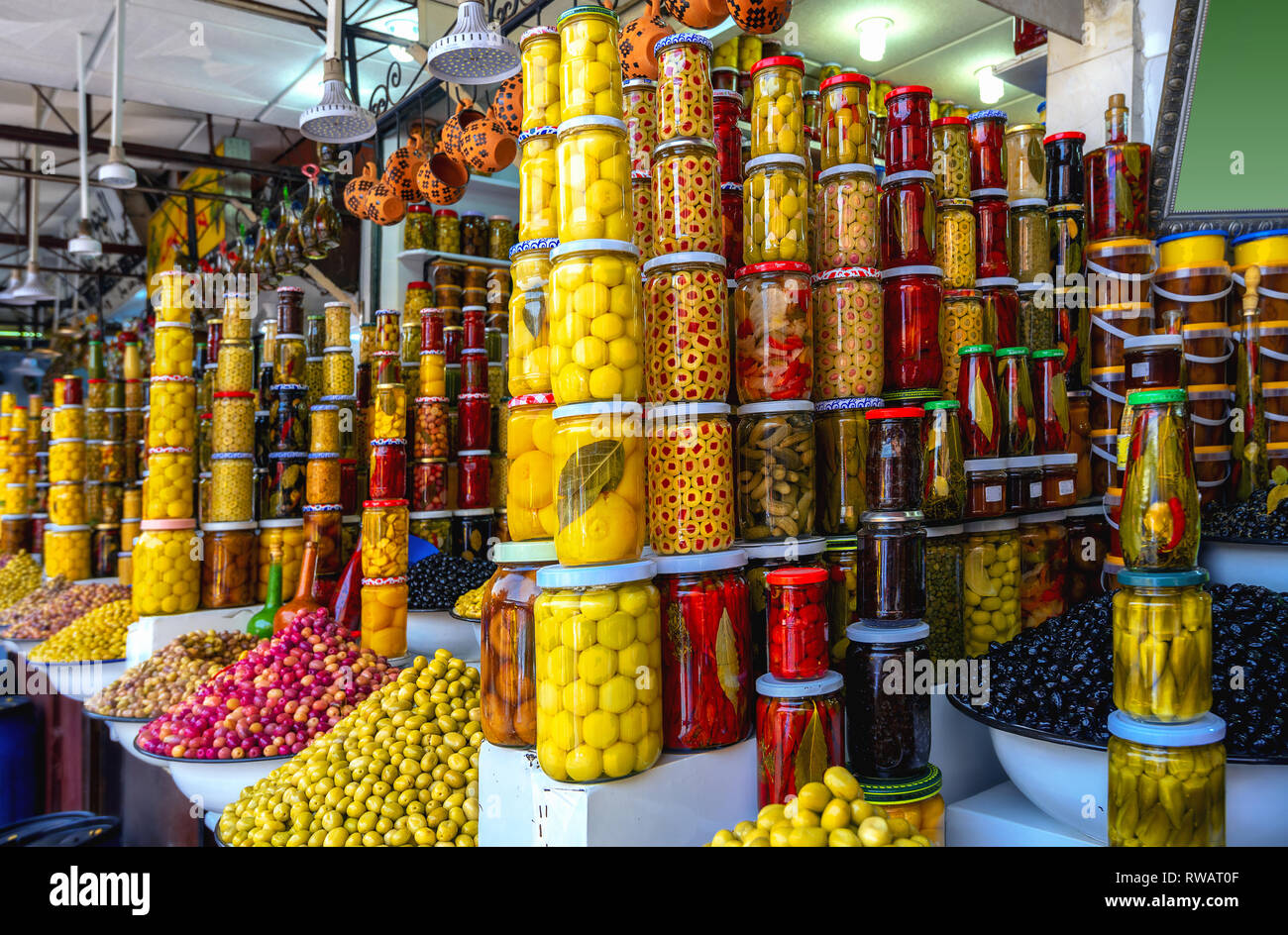Colorful stall for sale with olives, preserves, sauces, canned goods, spices at market in Jamaa el Fna in Marrakesh.  Morocco, North Africa Stock Photo