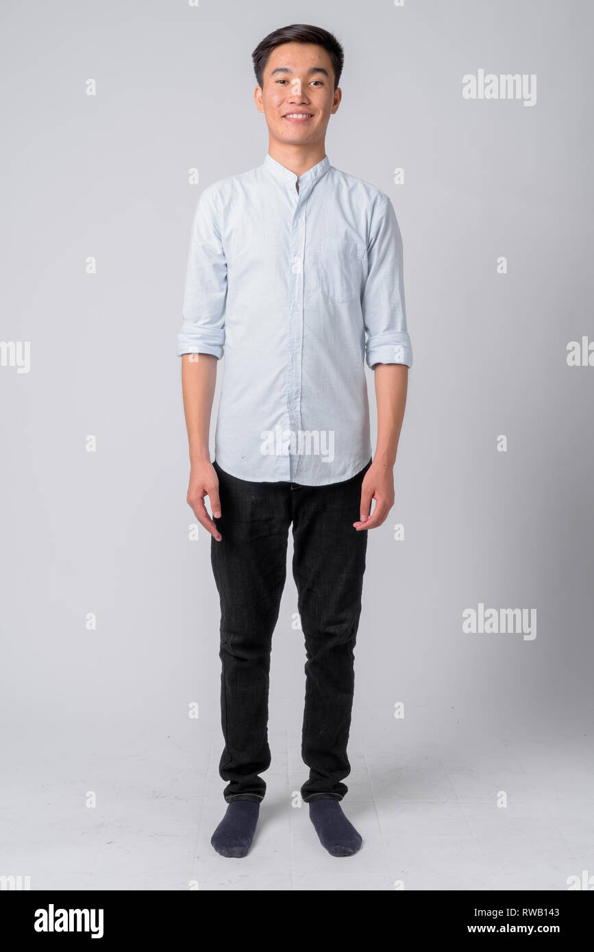 Full body shot of young happy Asian businessman smiling Stock Photo - Alamy