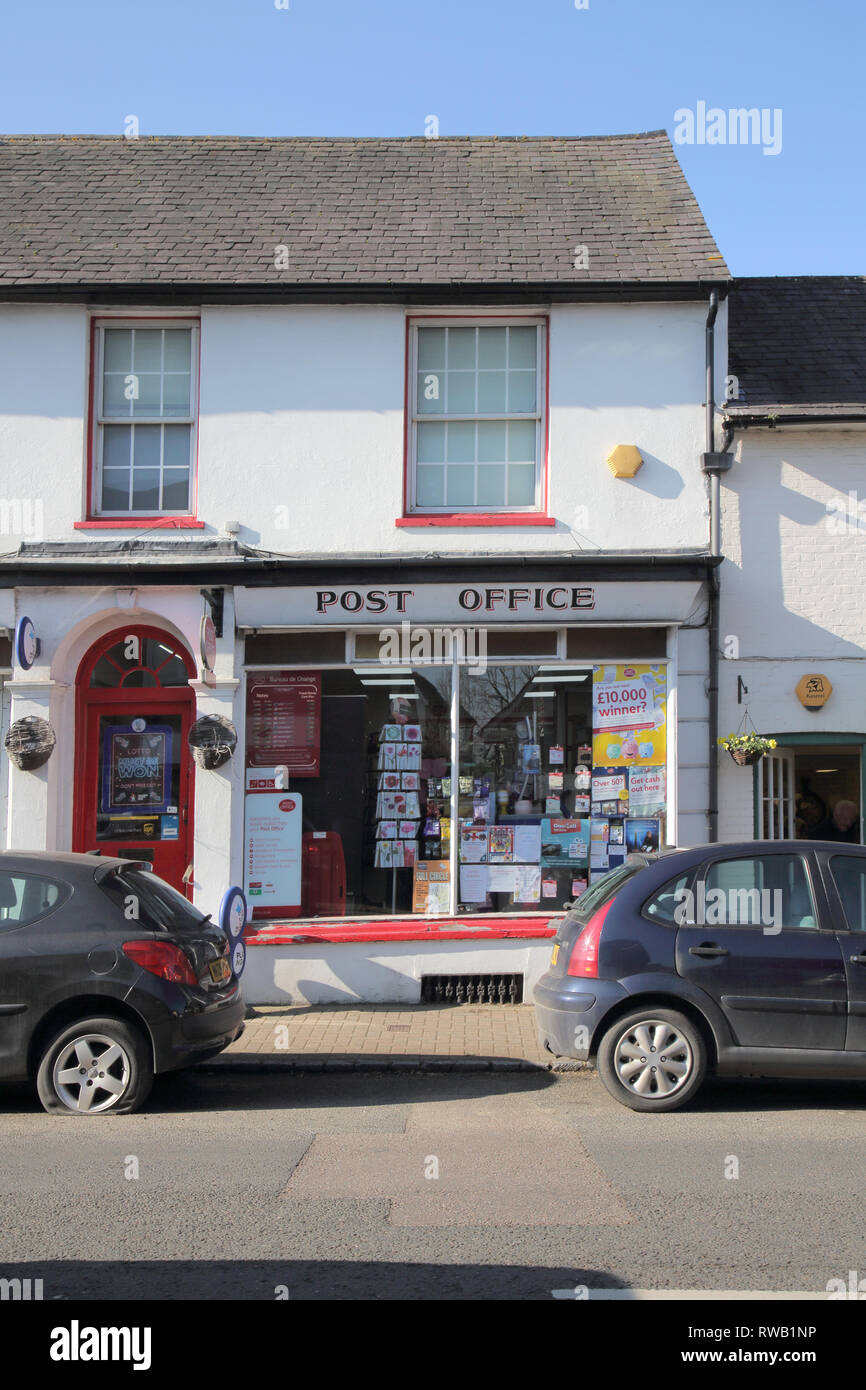 car with a flat tyre parked outside the post office in the large village of henfield in west sussex Stock Photo