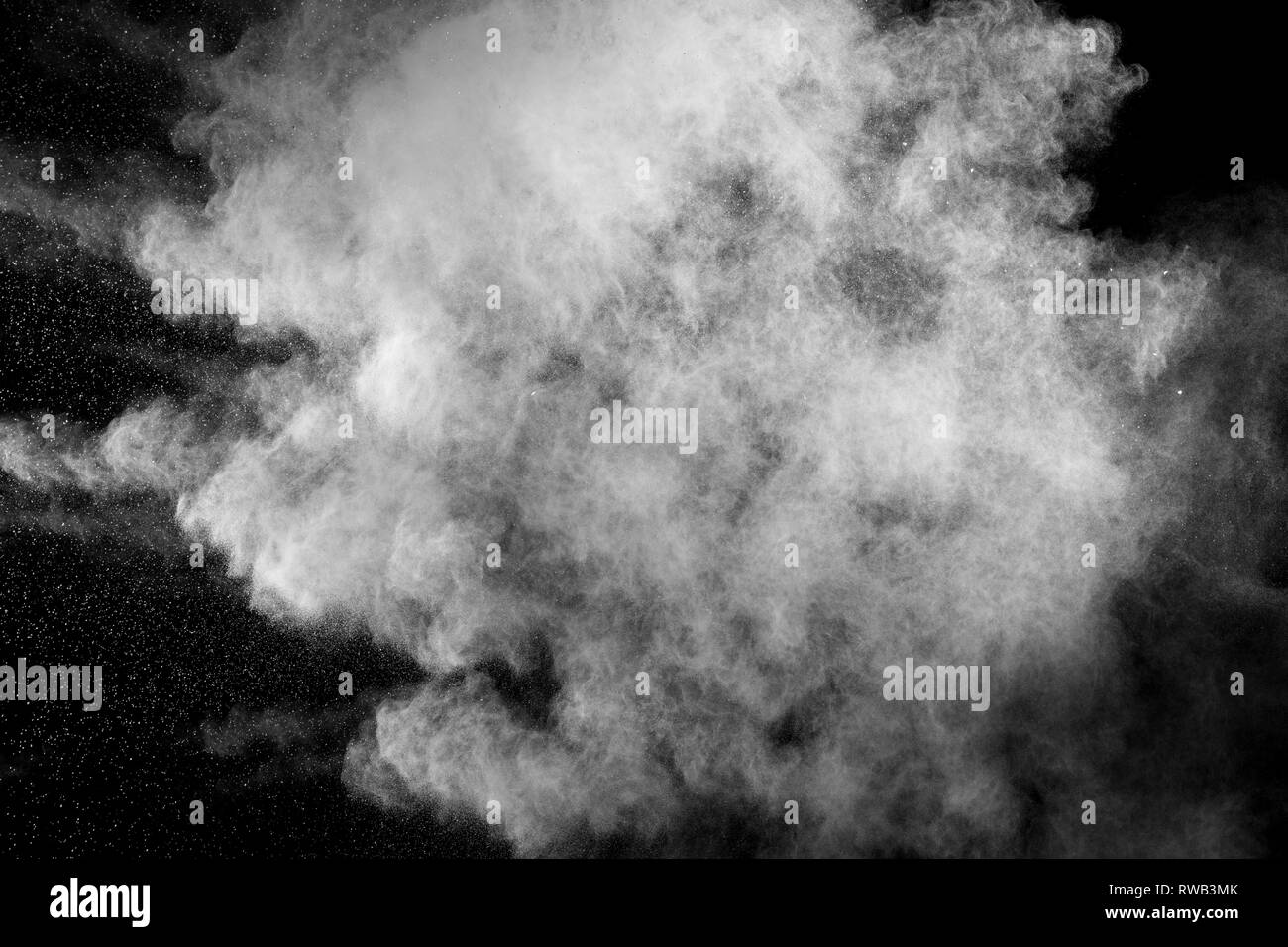 White dust exhale in the air. Motion powder spray burst in dark
