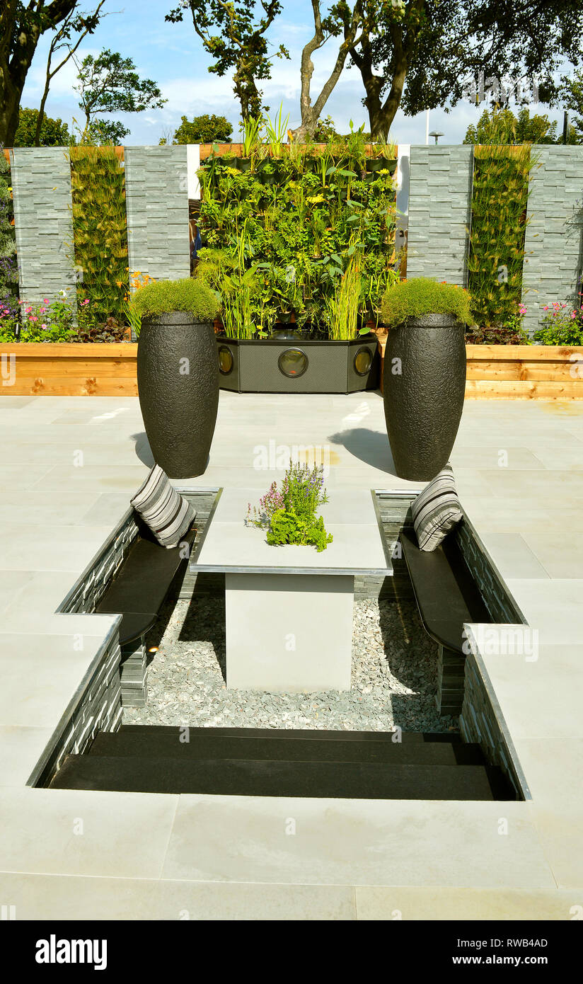 Low maintenance garden with a stone patio and sunken seating area Stock Photo