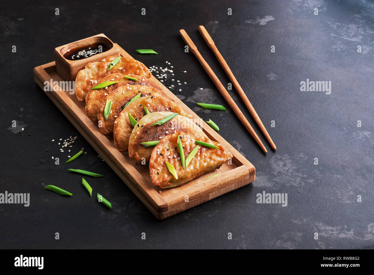 Asian food homemade fried dumplings on a dark background. Korean dumplings. Selective focus Stock Photo