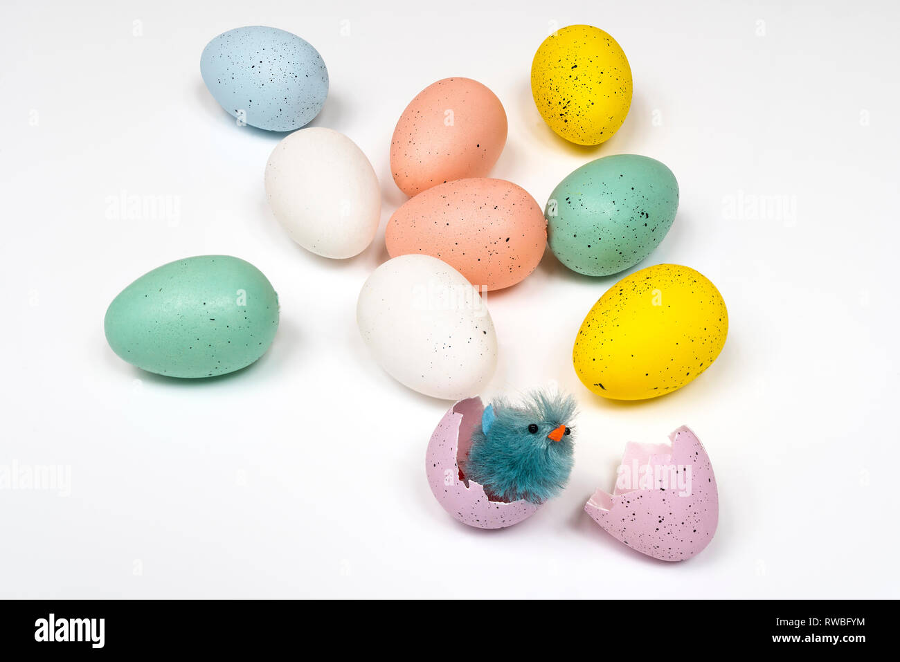 colored easter eggs with little chicks on a white surface Stock Photo