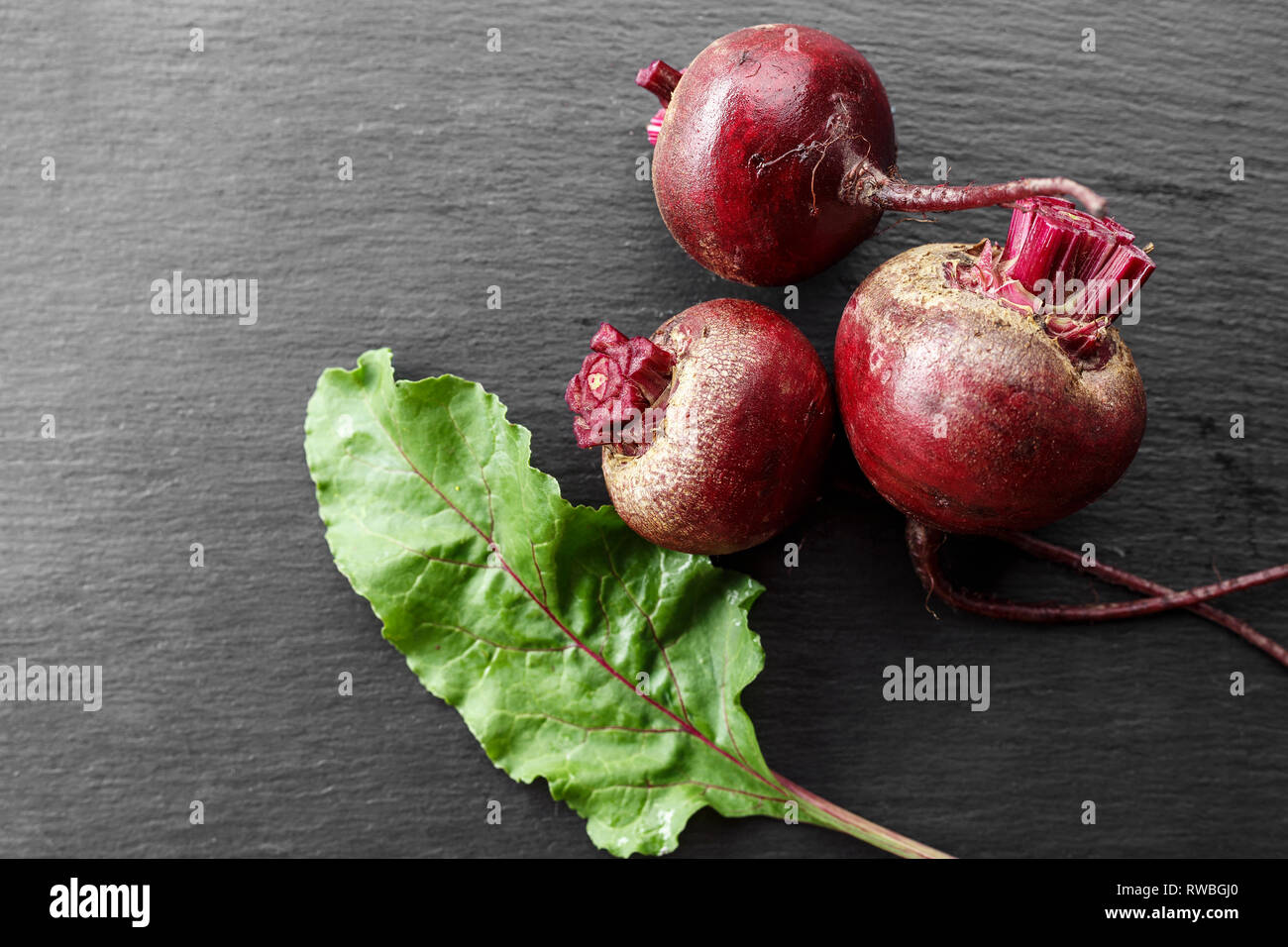 whole young beets on the table, on a black background. space for text Stock Photo