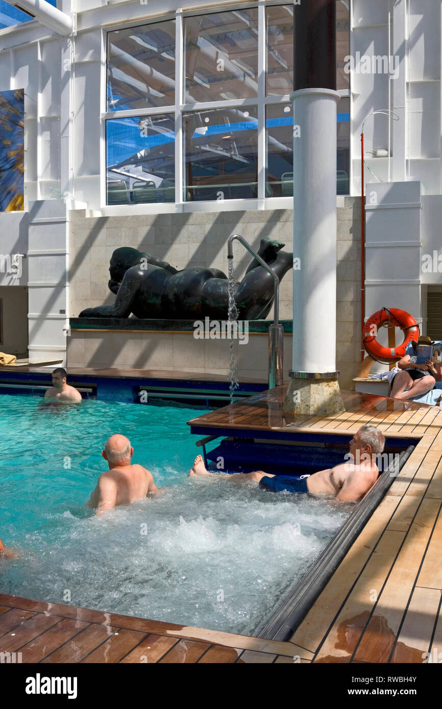 adults pool; people relaxing; large black sculpture; bubbling water; Celebrity Cruises, Summit cruise ship; recreation; vacation; vertical Stock Photo