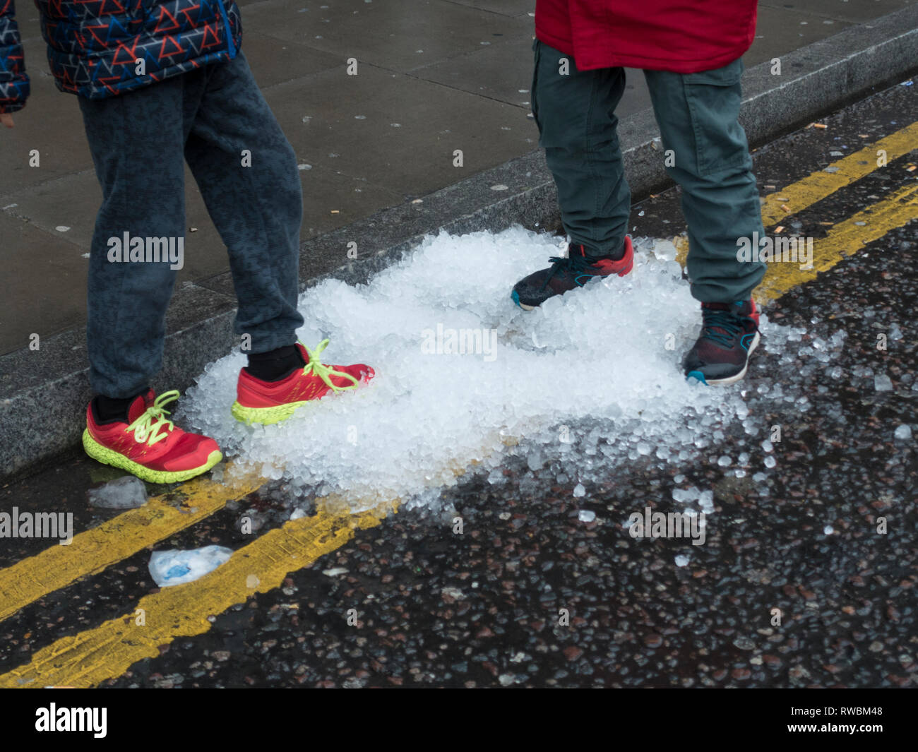 Children Kicking Snow Stock Photo