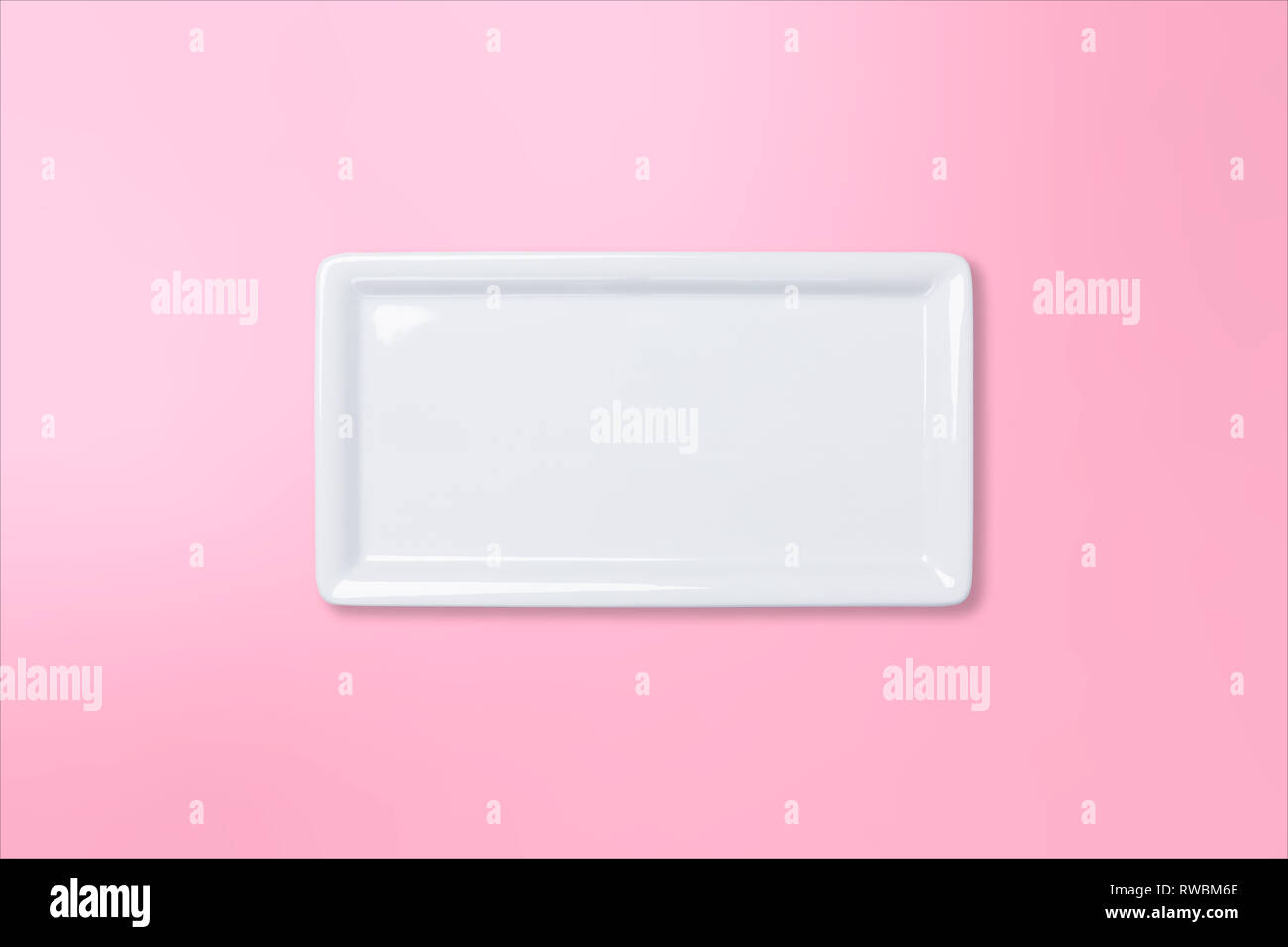 Empty white cornered plate on pink gradient background, view directly from above Stock Photo