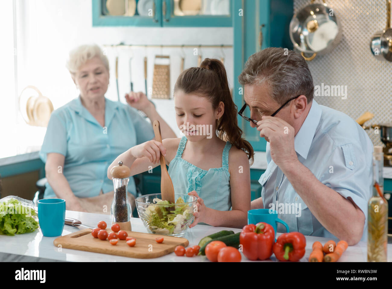 Granddad teaching granddaughter to cook Stock Photo - Alamy