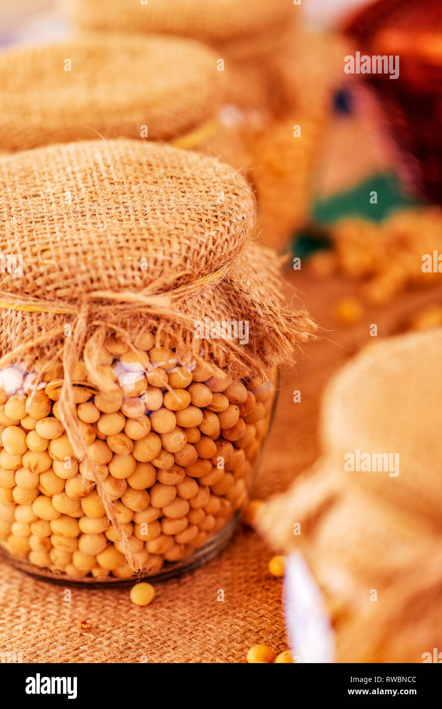 Organic raw soybean in glass jar, selective focus Stock Photo