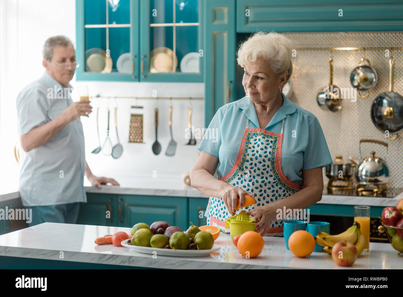 Old woman squeezing an orange Stock Photo