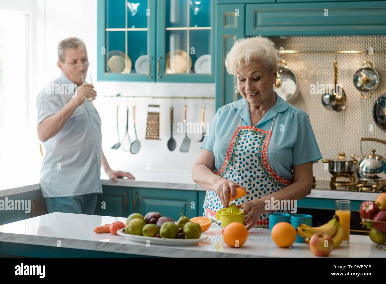 Grandmother squeezing an orange Stock Photo