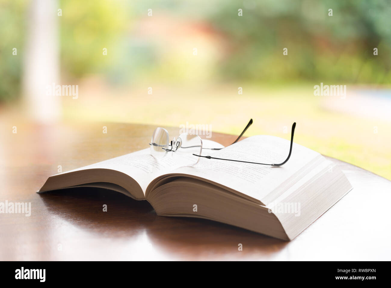 Reading glasses on top of a book Stock Photo