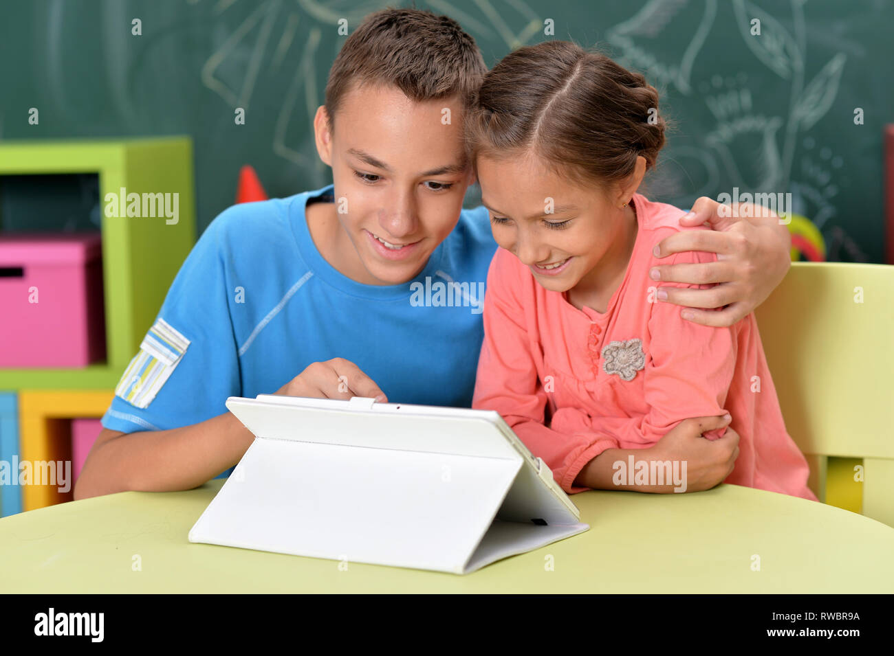 Portrait of brother and sister using tablet Stock Photo - Alamy