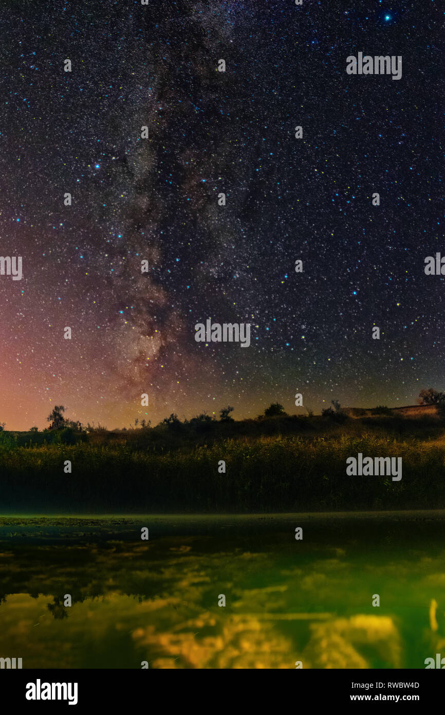 A Milky Way view above the lake. A lake at the night. Astronomy. Clear Night Sky Stock Photo