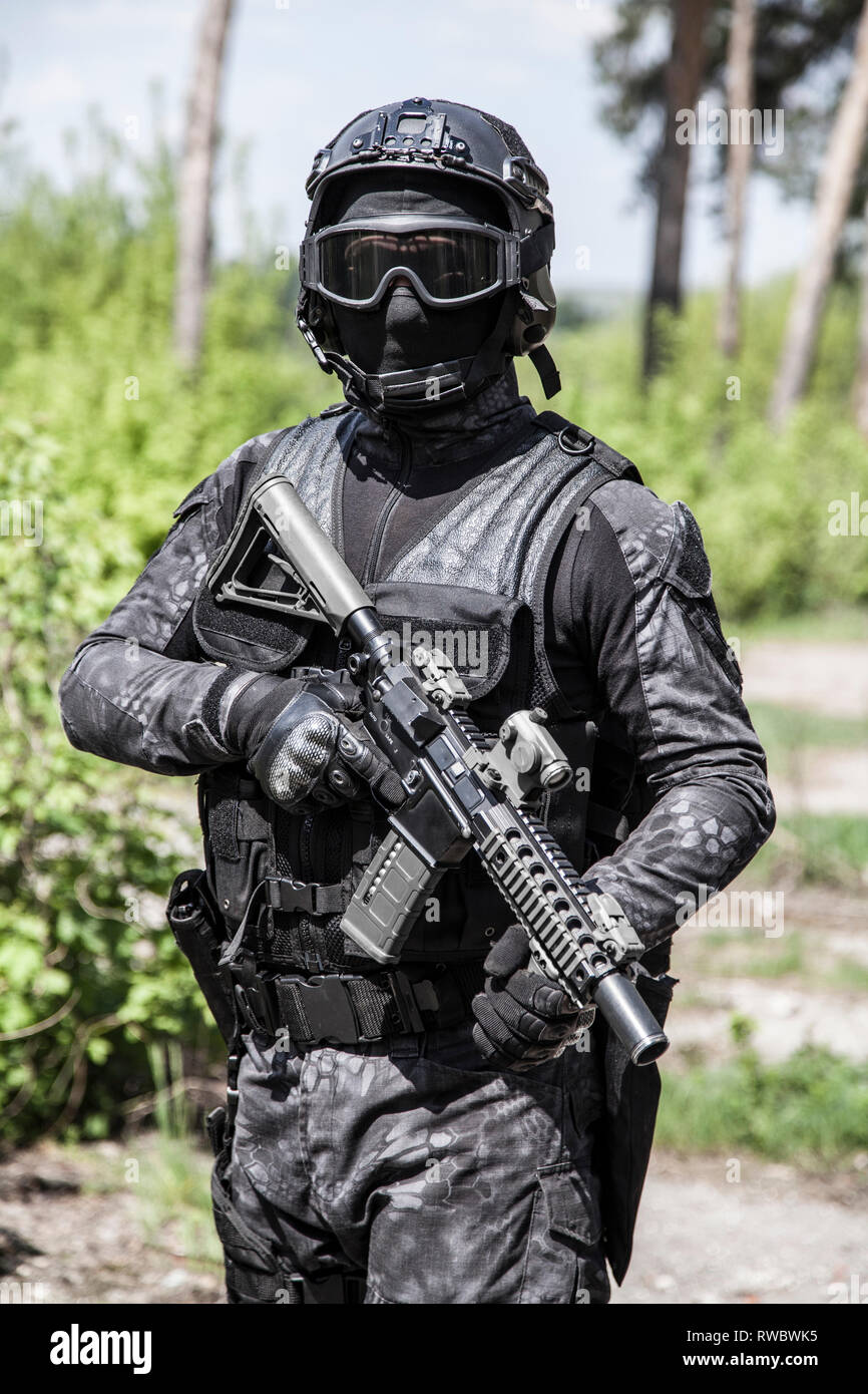 Spec ops police officer SWAT in black uniform in action Stock Photo - Alamy