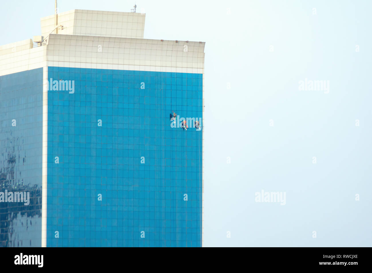 Workers washing windows in a skyscraper in Dubai. Stock Photo