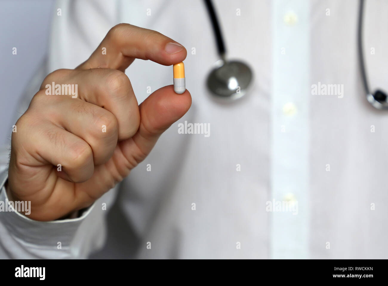Doctor with pill, man giving medication in capsule. Concept of medical exam, dose of drugs, vitamins, medical prescription, pharmacy Stock Photo