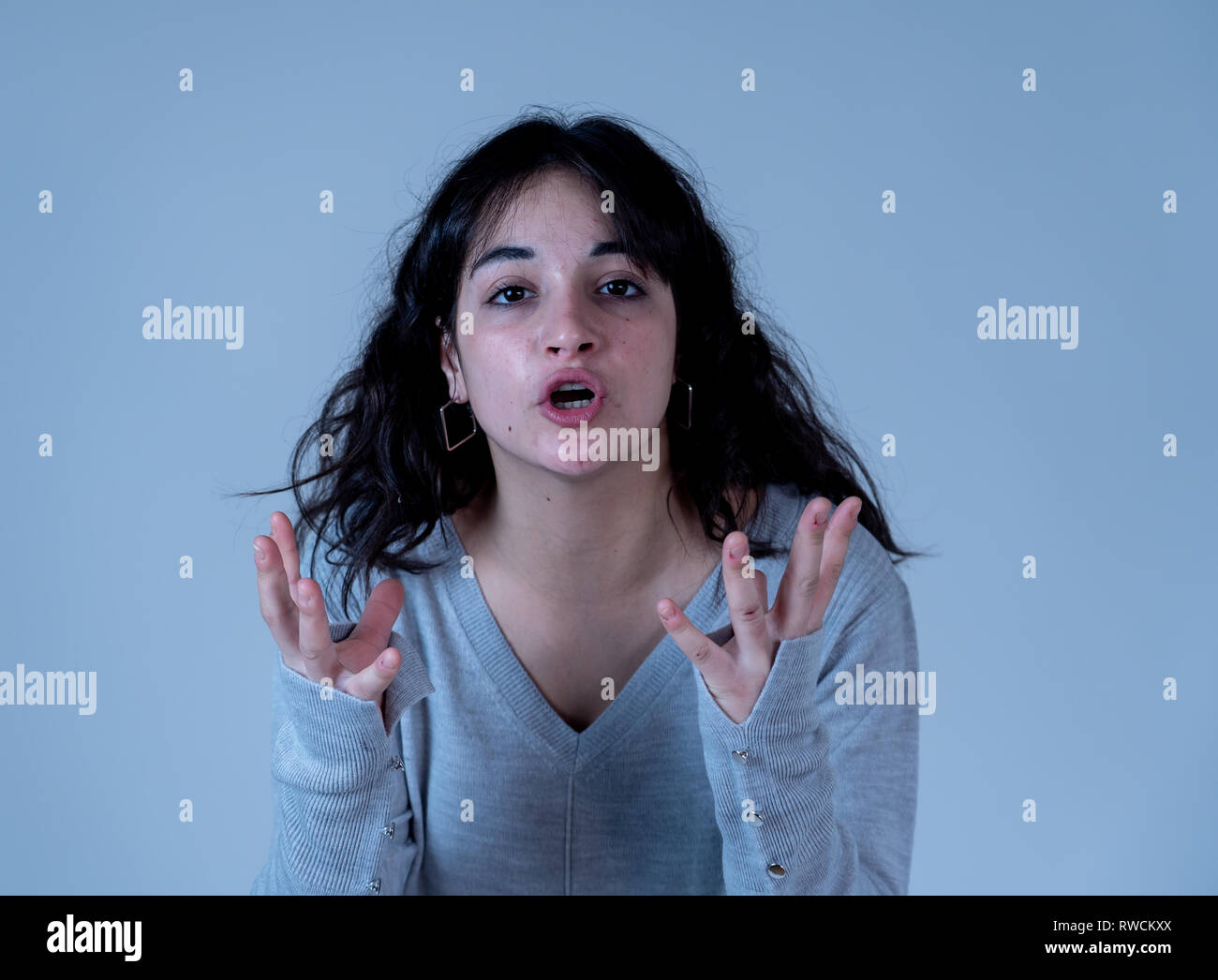 Facial expressions and emotions. Close up portrait of Young attractive hispanic woman with an angry face. Looking mad and crazy shouting and making fu Stock Photo