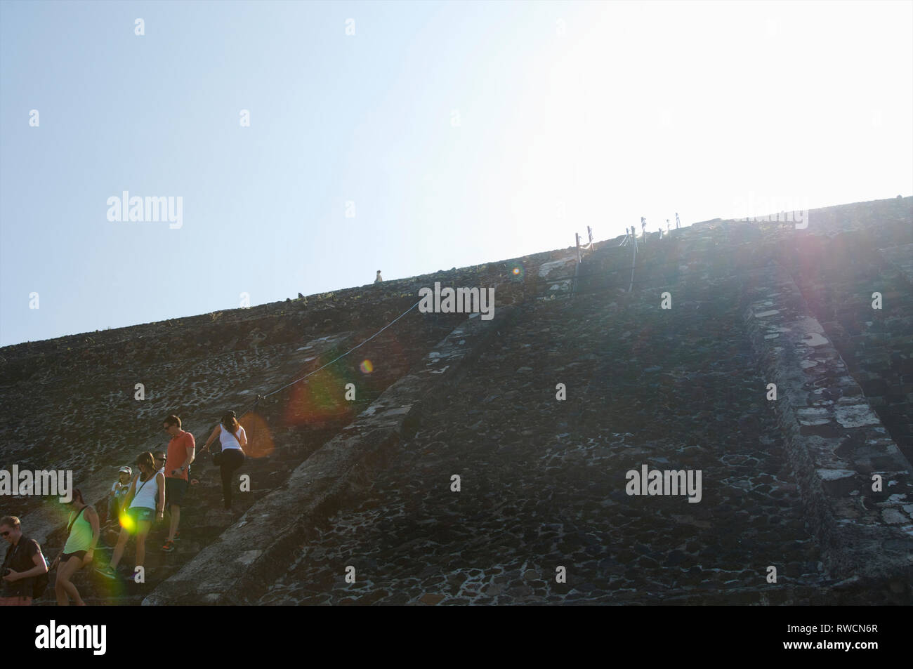 Sunshine and tourists on top of Pyramid of the Sun at Teotihuacan, Mexico Stock Photo