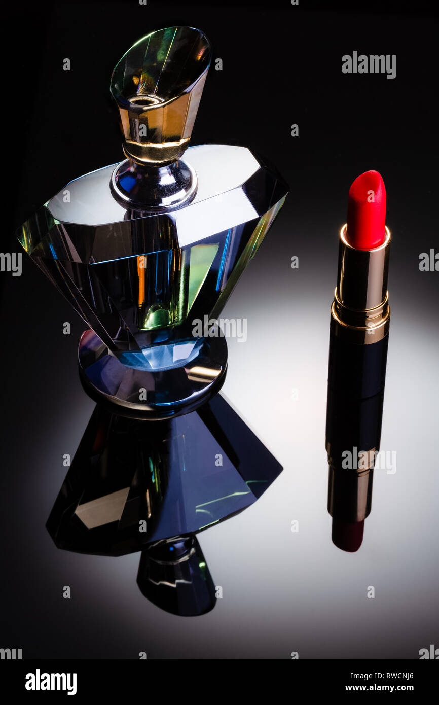 Perfume bottle and lipstick studio still life, perfume bottle has different colours. Stock Photo