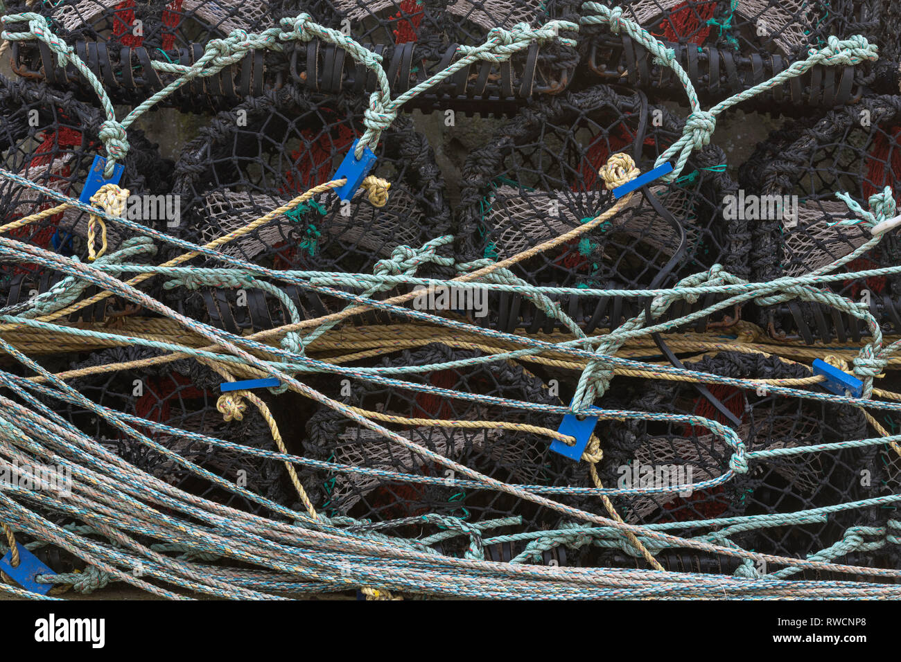 Creels With Rope Stacked in the Harbour in a Scottish Fishing Village Stock Photo