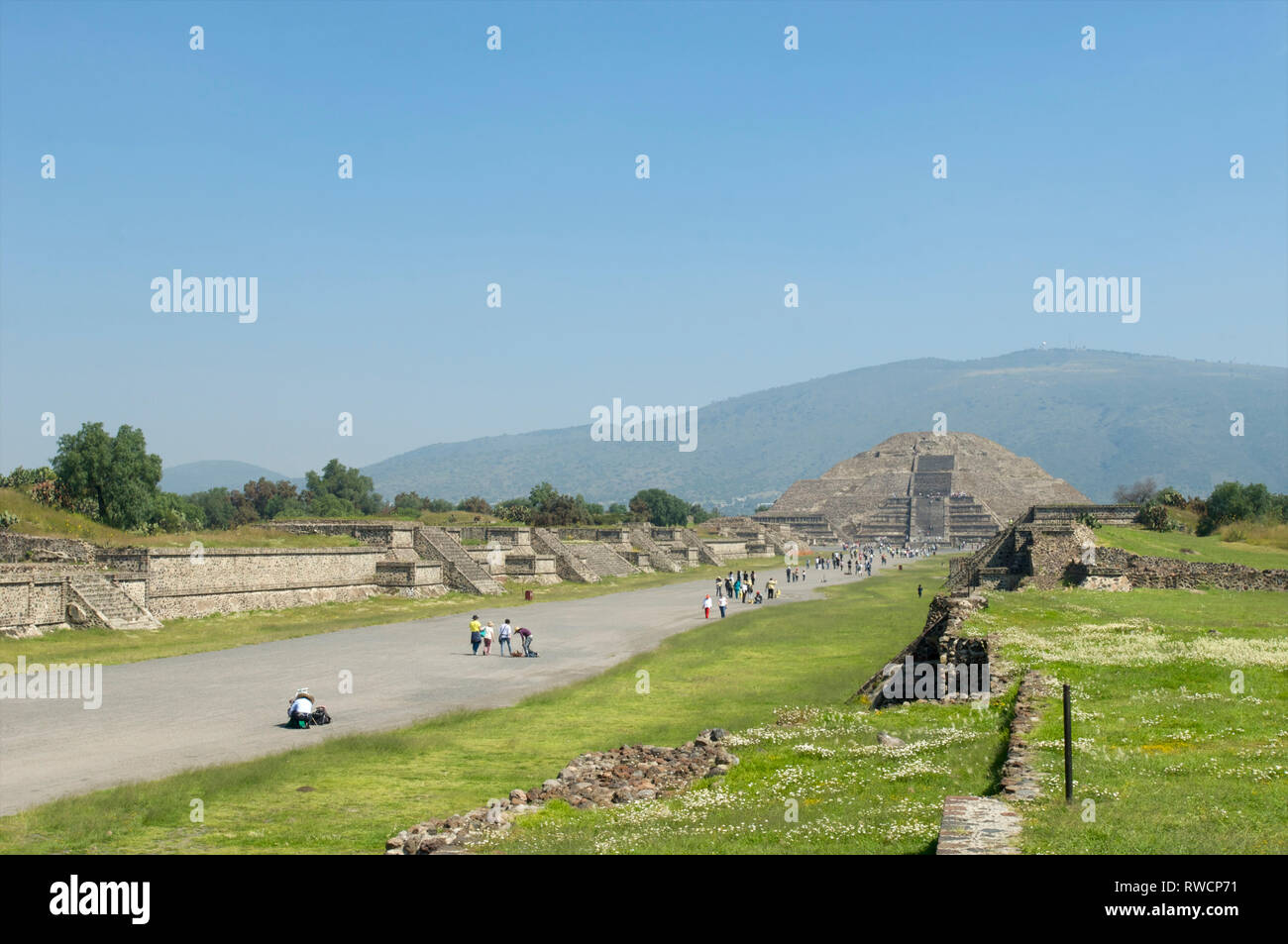 Tourists walking on Avenue of the Dead and the view of Pyramid of the Moon at Teotihuacan, Mexico Stock Photo