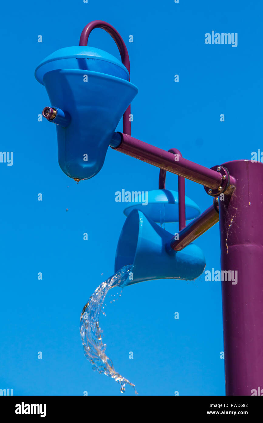 Blue plastic bucket dumping water at a water park Stock Photo