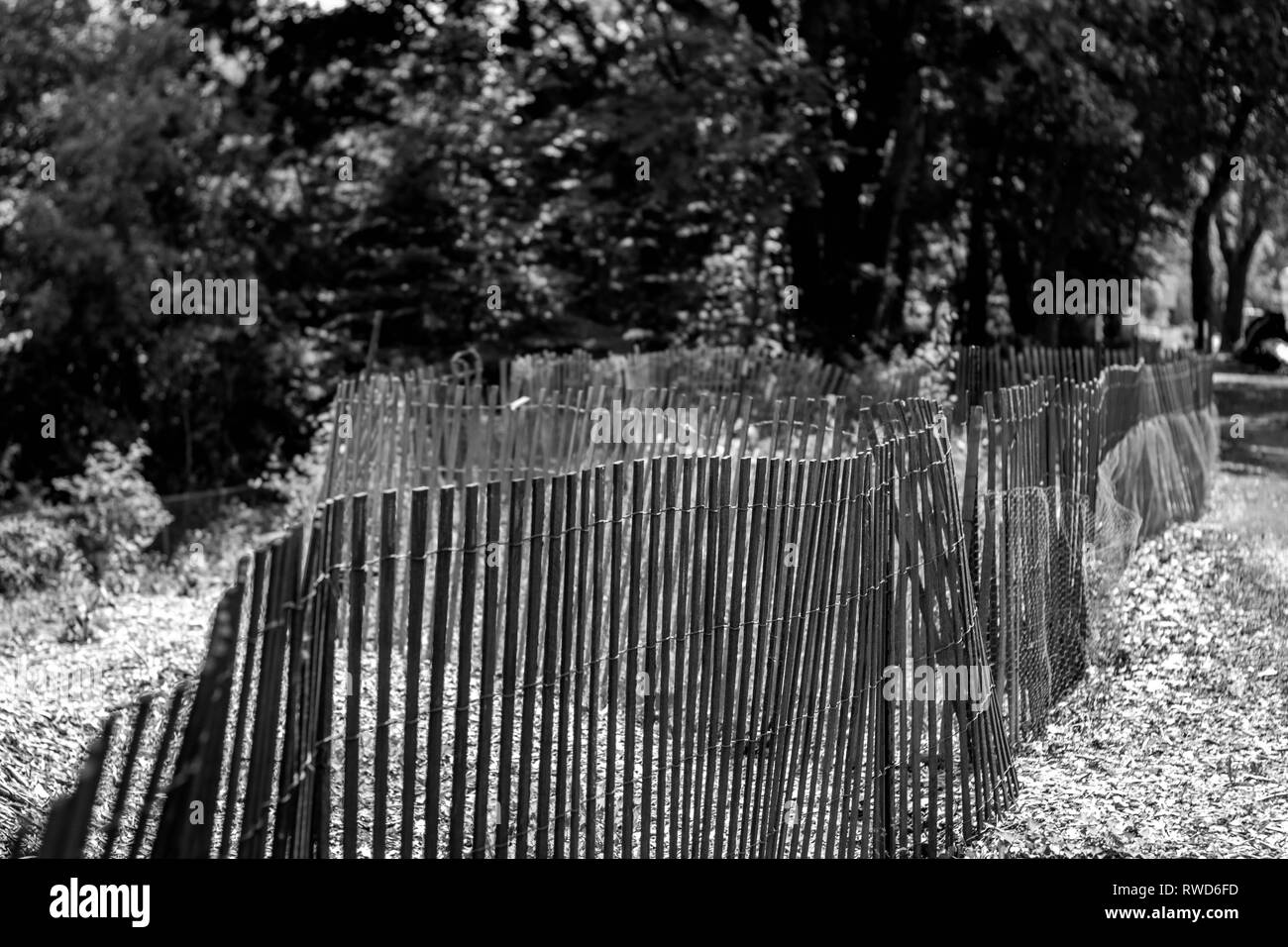 Uneven snow fence set up on a bike path Stock Photo