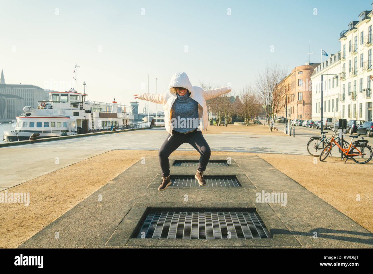 adult person rejoices like child. Playground trampoline in ground