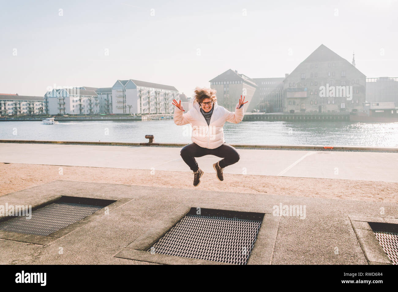 adult person rejoices like child. Playground trampoline in ground