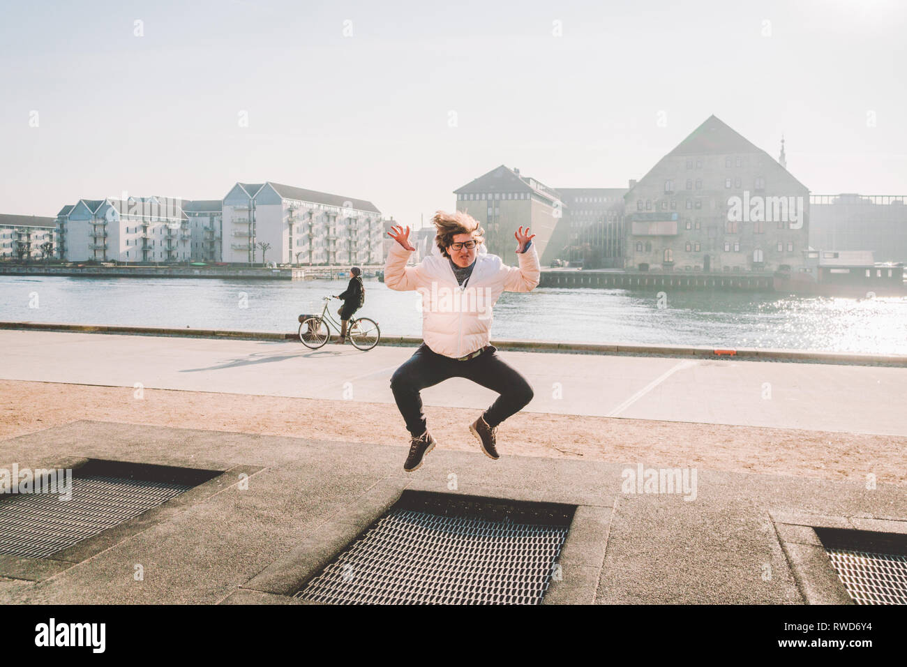 adult person rejoices like child. Playground trampoline in ground, children  trampoline, springs throws people up fun and cool. Copenhagen River Embank  Stock Photo - Alamy