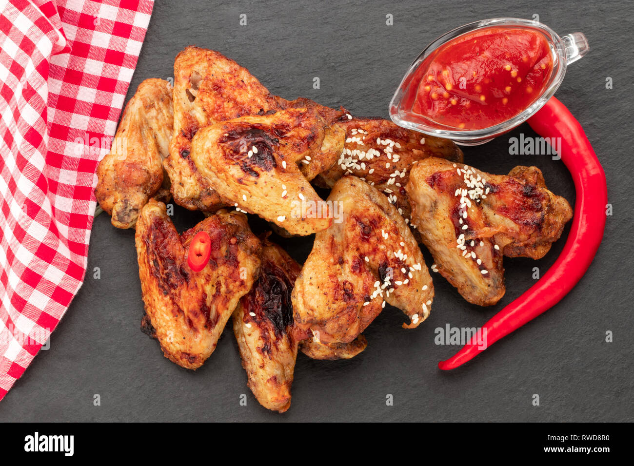 Baked chicken wings with sesame and sauce. Food background. Top view