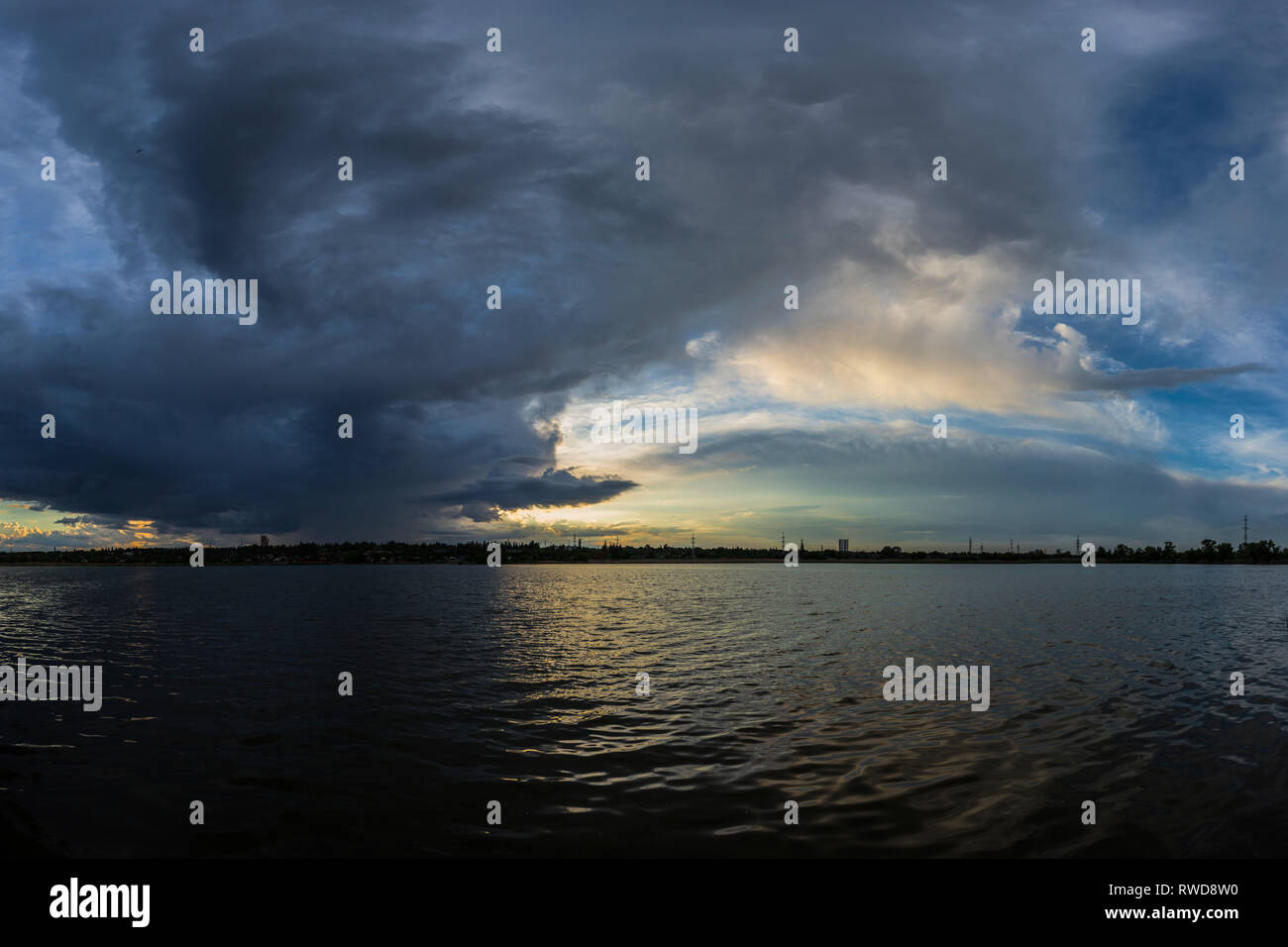 Epic dark cloudy landscape with thunderstorm clouds over the lake that highlighted by sun light, river in Kriviy Rih, Dnipropetrovsk region, Ukraine Stock Photo