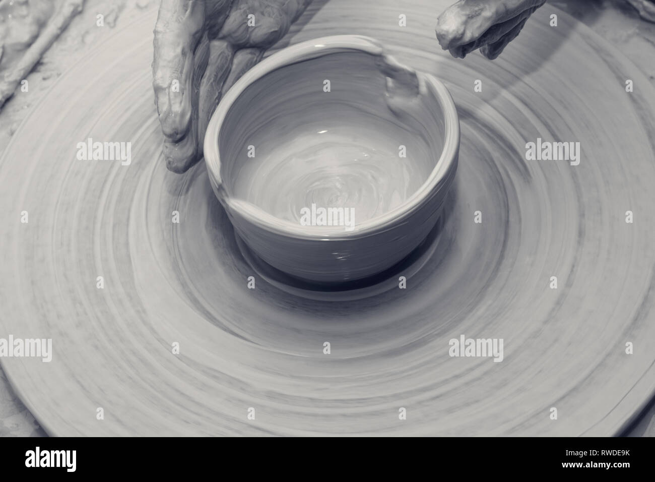 Process of making clay bowl on pottery wheel. Black and white toned