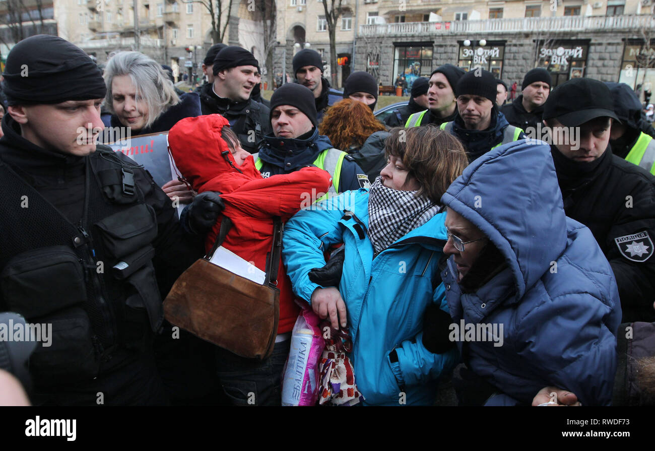 Ukrainian activists are seen blocking road traffic along the central thoroughfare and policemen are trying to stop them, in front the Kiev City Hall, during the protest. Protest against illegal construction in Kiev, Ukraine,  the protesters held placards saying 'Save Kiev!', Mayor, stop corruption', 'We will not allow to demolish historical buildings!' and others as they demand that the mayor Vitali Klitschko and the city council to stop what they call illegal construction sites such as huge residential complexes and shopping malls and to preserve historical landscape of Kiev. Stock Photo