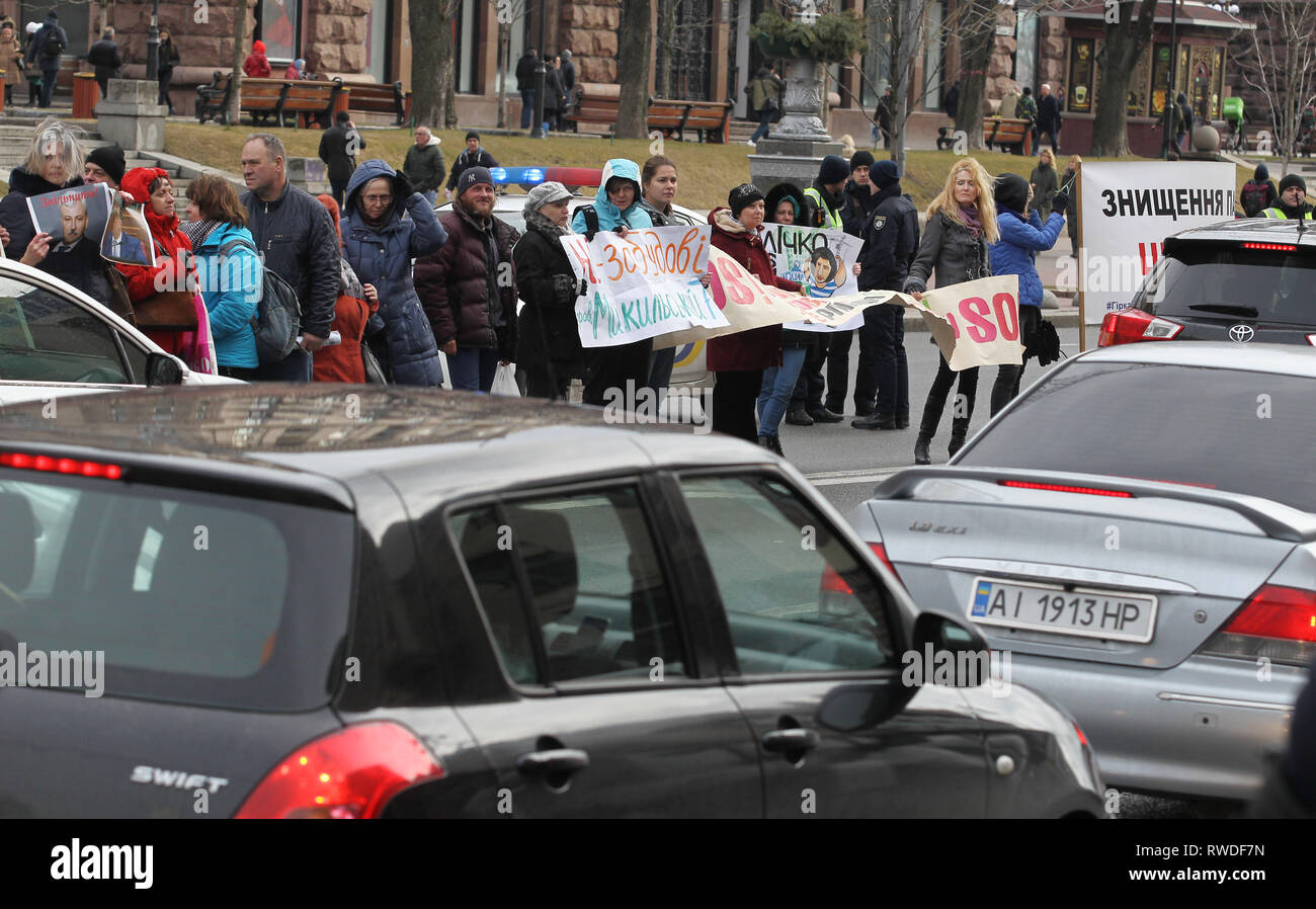 Ukrainian activists are seen holding a banner and placards while blocking road traffic along the central thoroughfare in front the Kiev City Hall, during the protest. Protest against illegal construction in Kiev, Ukraine,  the protesters held placards saying 'Save Kiev!', Mayor, stop corruption', 'We will not allow to demolish historical buildings!' and others as they demand that the mayor Vitali Klitschko and the city council to stop what they call illegal construction sites such as huge residential complexes and shopping malls and to preserve historical landscape of Kiev. Stock Photo