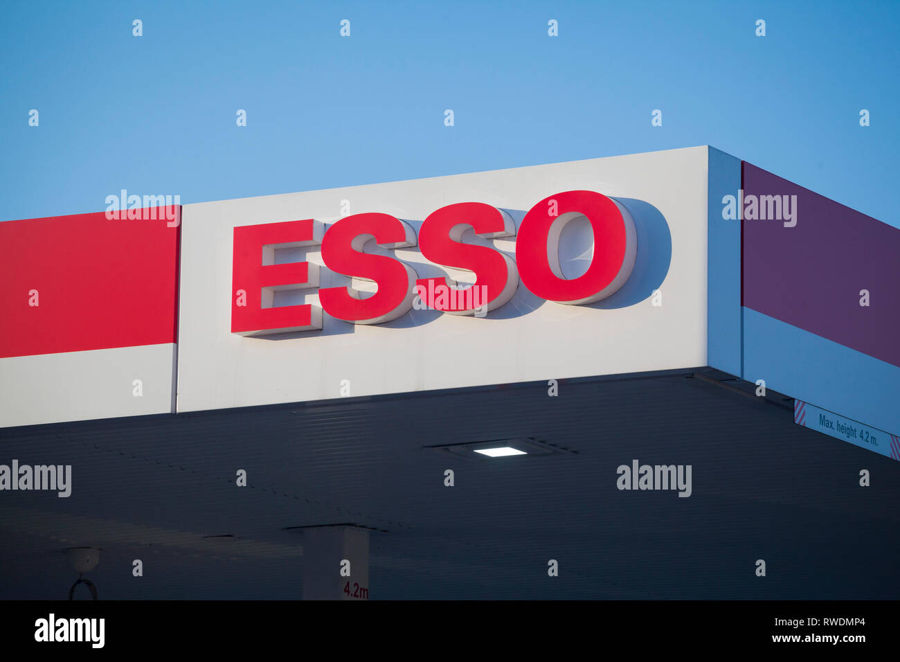 The Esso sign on the side of a garage against clear blue sky. Stock Photo
