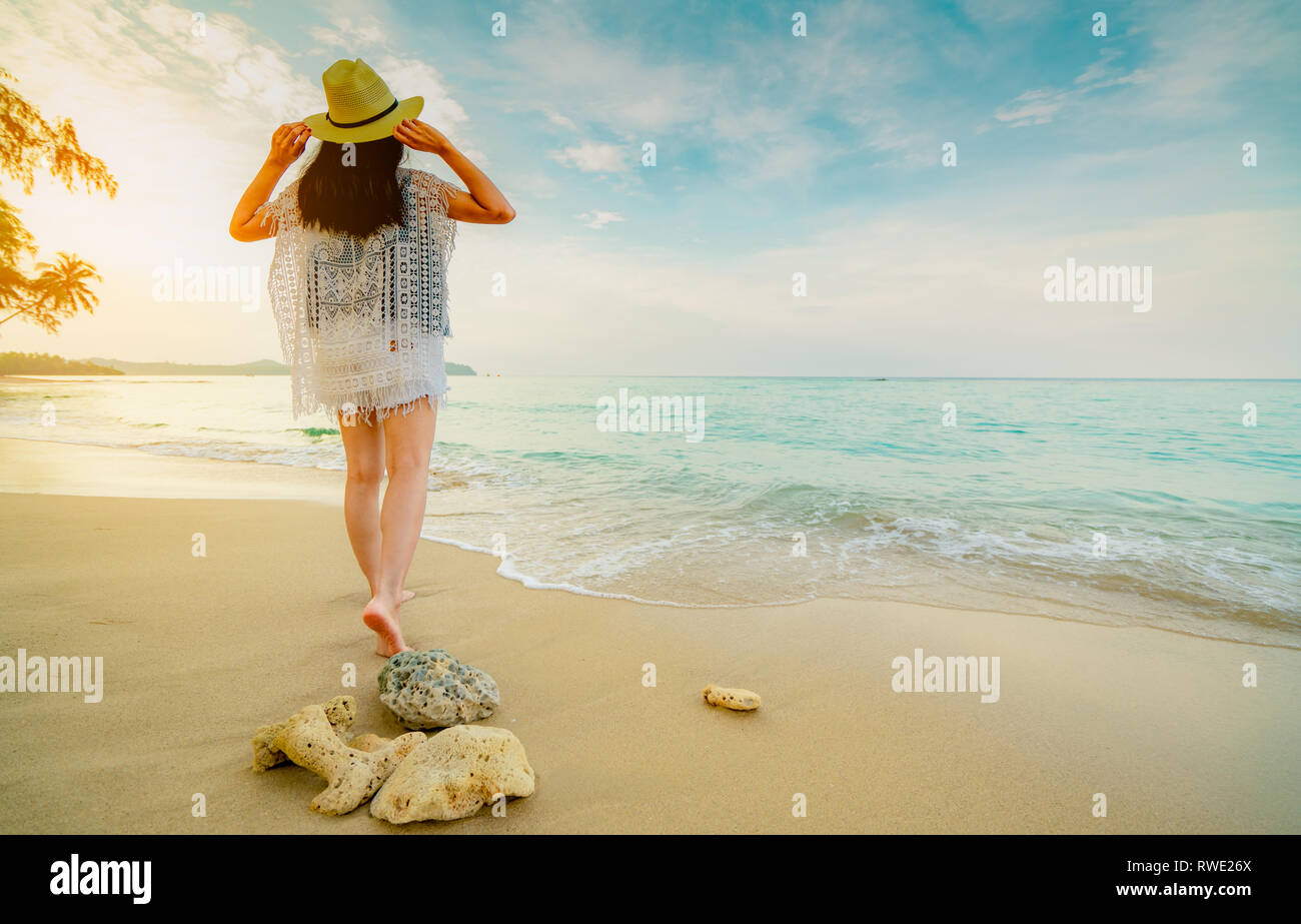 Happy Young Woman Wear Straw Hat Walking On The Beach Relaxing