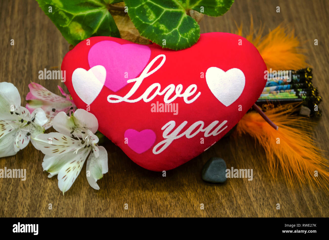 Little flowers, colored feathers, leaves next to a red heart with painted pink and white hearts and the words Love you, on polished boards Stock Photo - Alamy Little flowers, colored feathers, leaves next to a red heart with painted pink and white hearts and the words Love you, on polished boards Stock Photo - Alamy