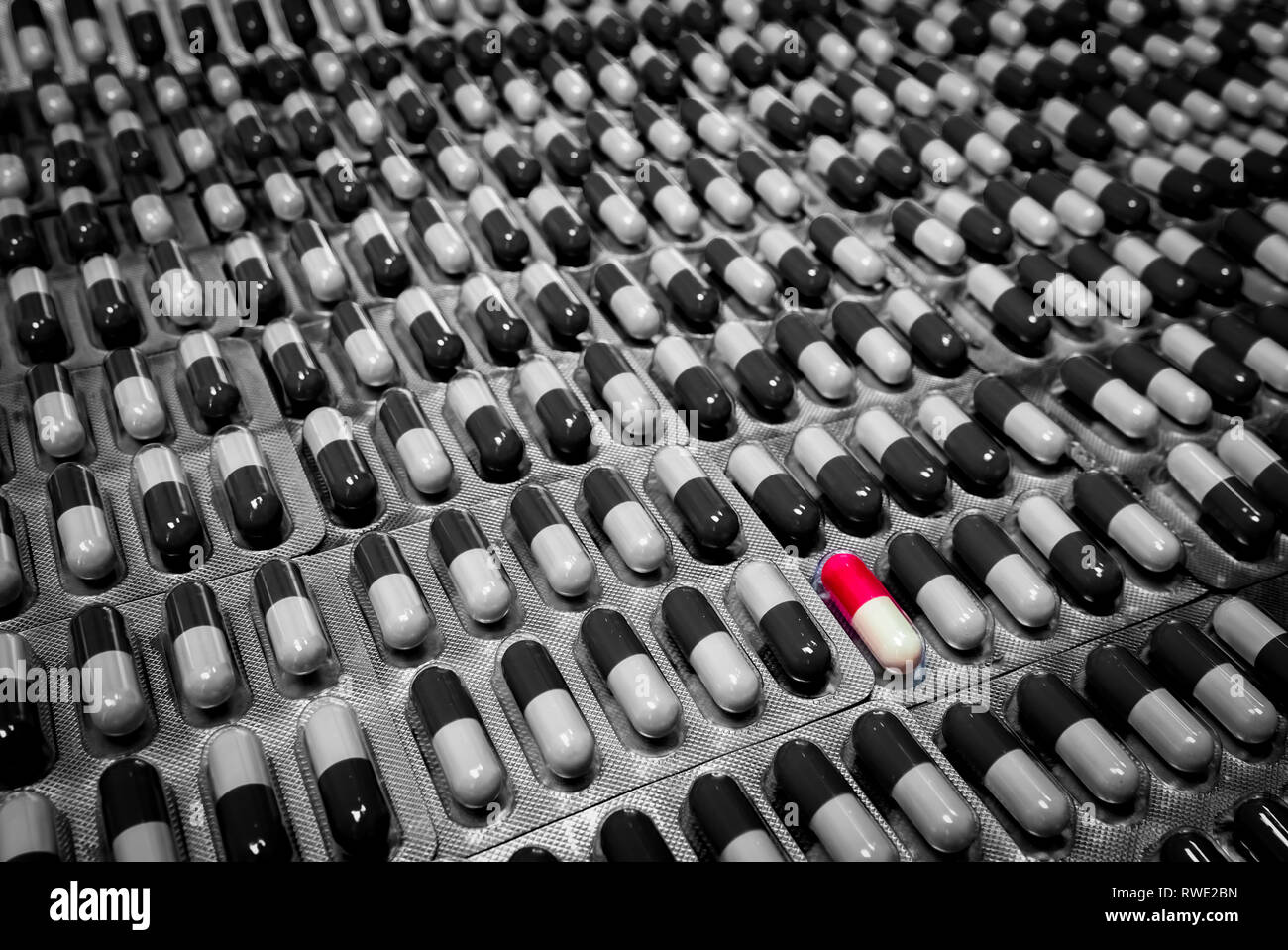 Red and white capsule in monochrome capsule pill in blister pack