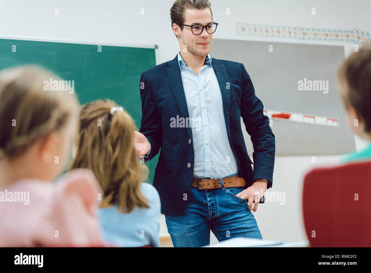 Teacher standing in front of students in school class Stock Photo