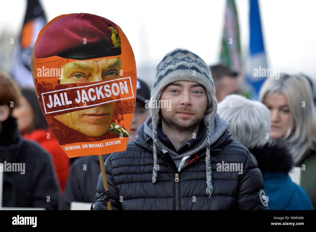 Marcher at the 47th Bloody Sunday commemoration march in Londonderry on 27 January 2019 with a Jail Jackson poster, calling for the jailing of British Stock Photo