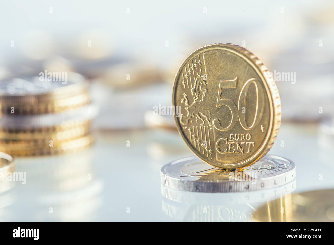 Euro coin balances on another coin and several loose coins Stock Photo